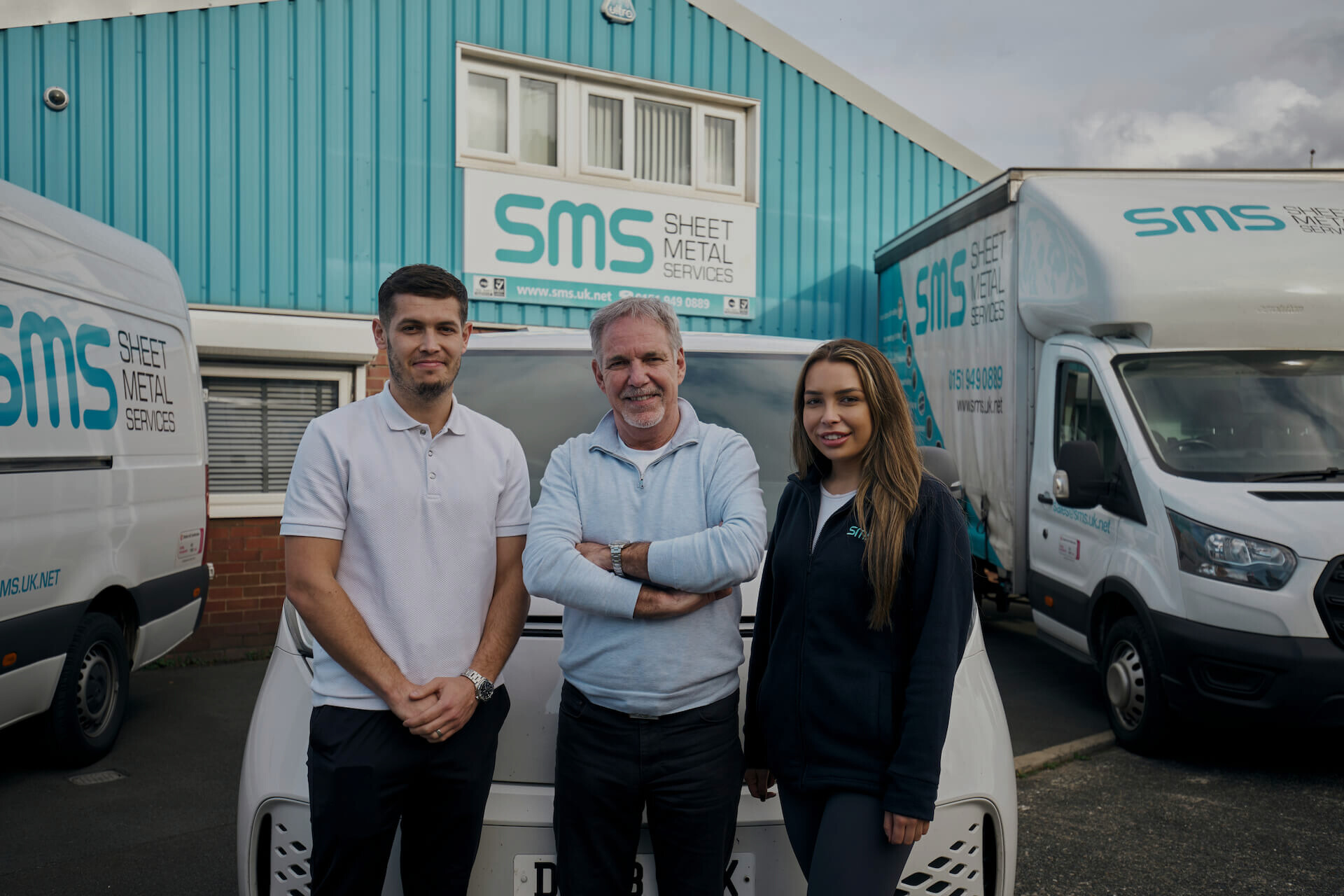 The team at sheet metal services stood in front of their facility